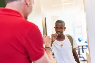 Docent en leerling geven elkaar een boks.