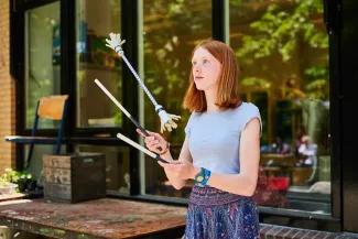 Leerling jongleert met een flower stick.