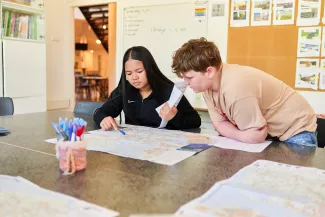 Leerlingen kijken samen op een landkaart.