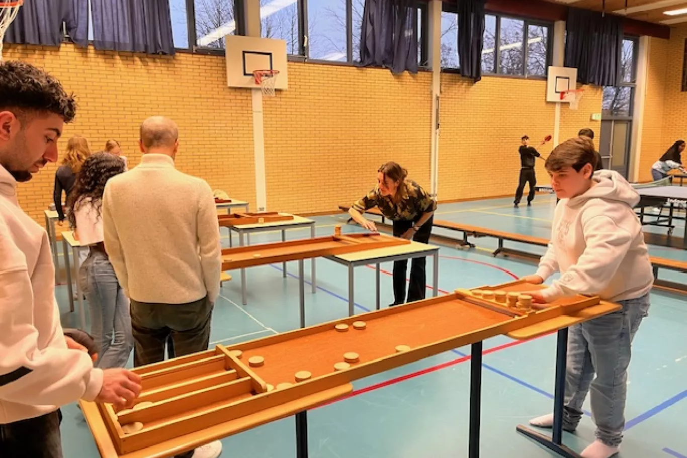 Leerlingen sjoelen tijdens de Wintermarkt.