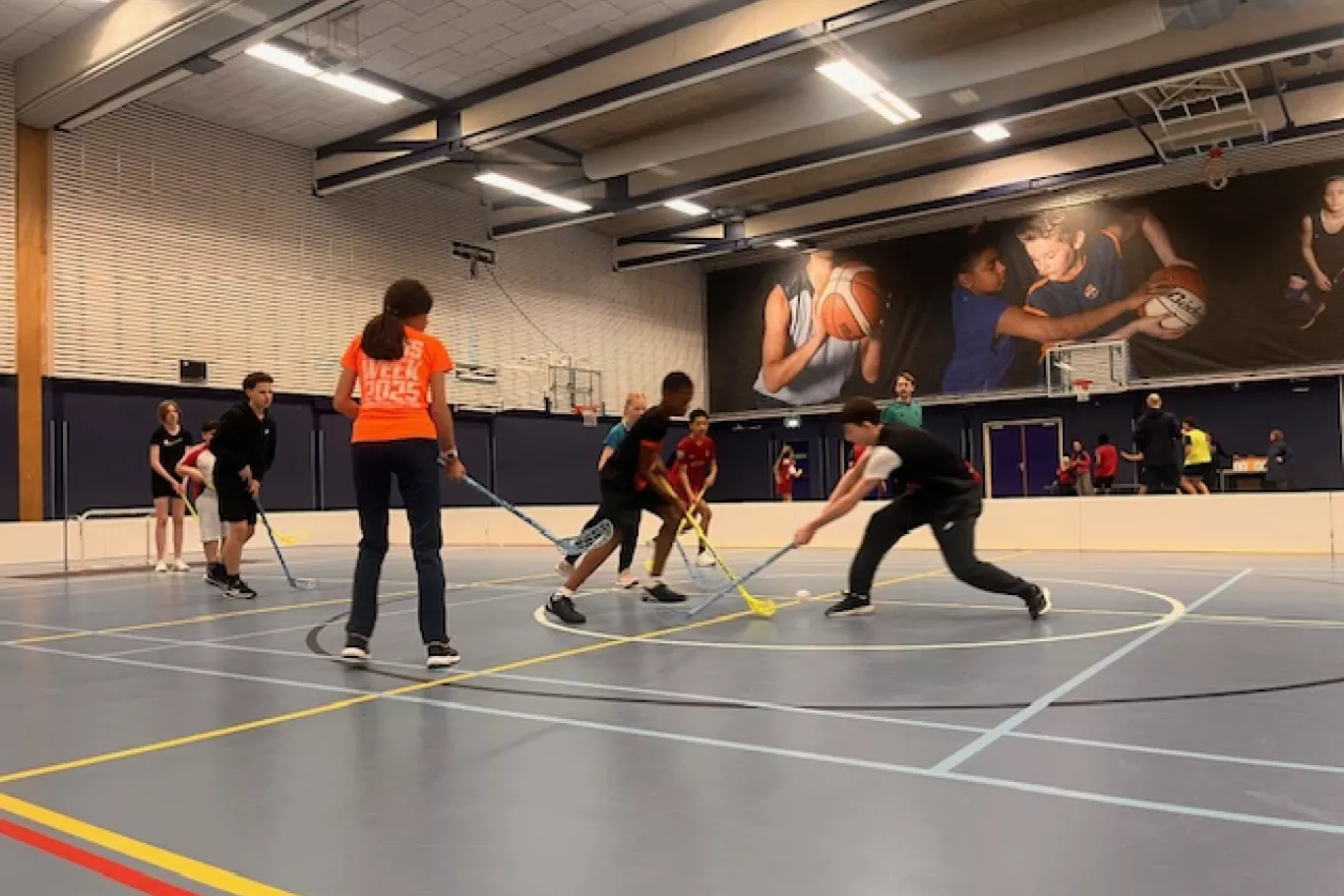 Leerlingen van de Simon van Hasseltschool spelen samen unihockey.